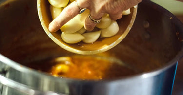 Gardener pouring fresh garlic into a pot.