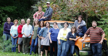 Group of home gardeners lined up along an orange truck