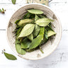 Whole dried bay leaves in a rustic basket.