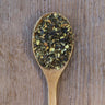 Dark Green Jalapeno Chili Pepper flakes on a rustic wooden spoon.