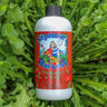 Bottle of Neptune's Harvest Tomato & Veg fertilizer on a bed of healthy green leaves
